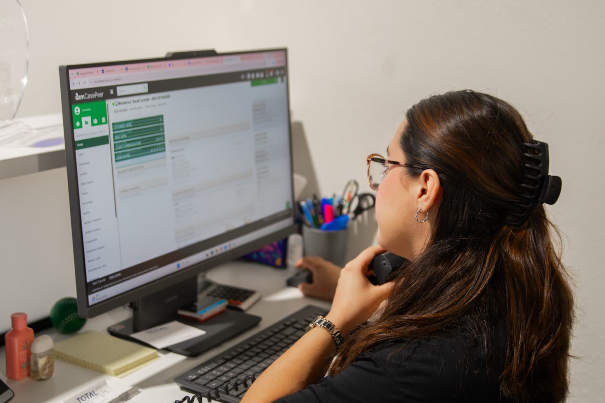 Integrante del equipo atendiendo un caso por teléfono en la oficina de Mesa